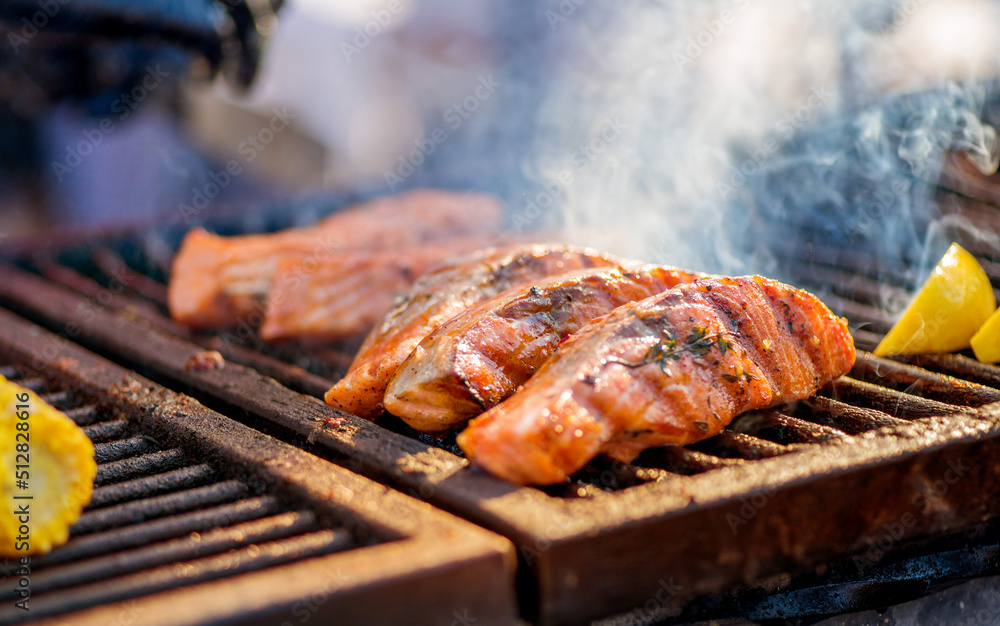 Fotografia do Stock Cooking BBQ Fish. Gloved hands turn pieces of fish