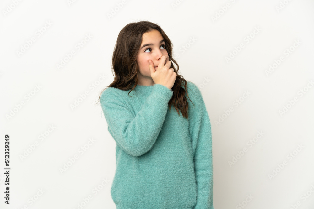 Little caucasian girl isolated on white background having doubts and with confuse face expression Little caucasian girl isolated on white background having doubts and with confuse face expression