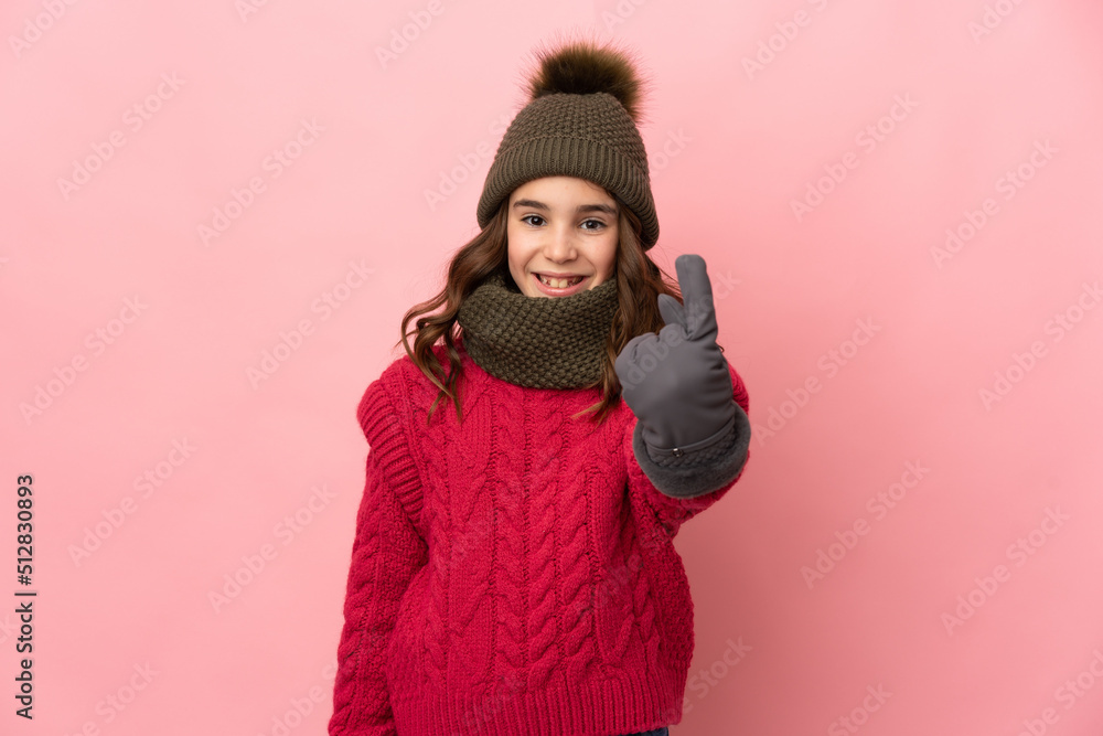 Little girl with winter hat isolated on pink background doing coming gesture Little girl with winter hat isolated on pink background doing coming gesture