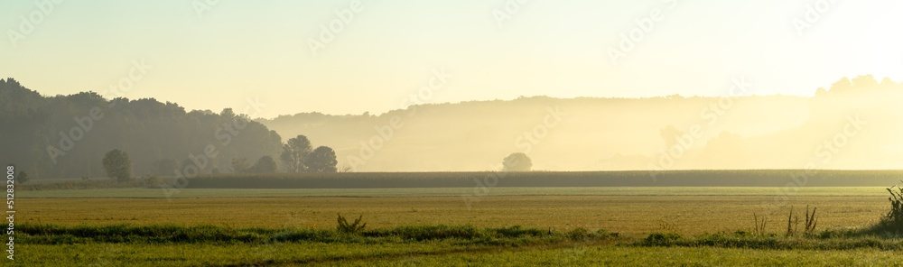Open farm fields with wooded hills in the background in the golden morning sun light | Amish country, Ohio