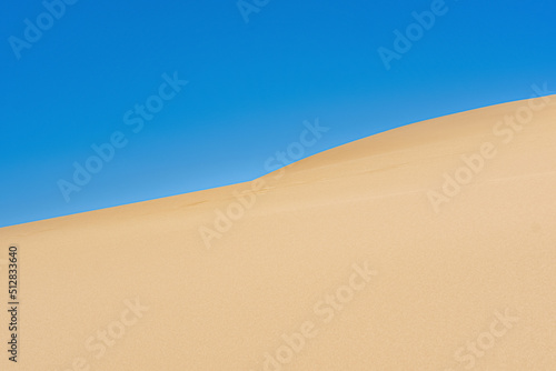 desert landscape  slope of a high sand dune against a blue sky