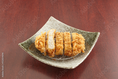 Tonkatsu served in a dish isolated on wooden table background side view of singapore food
