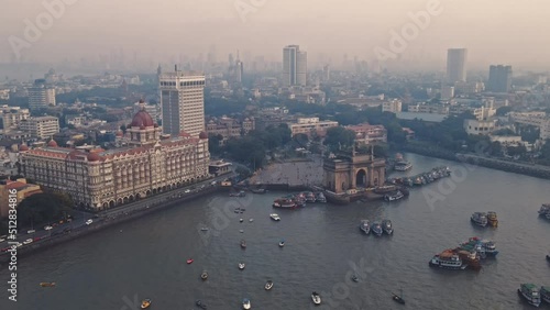 Aerial view of Gateway of India. Cityscape of old Mumbai town. Early morning weather on the seashore of Mumbai. Drone view of Taj Palace Hotel. Fishings boats sail in the sea during sunrise. photo