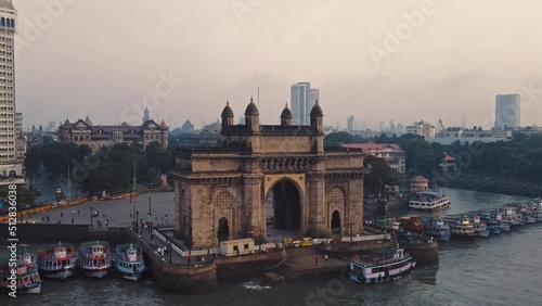 Aerial view of Gateway of India. Cityscape of old Mumbai town. Early morning weather on the seashore of Mumbai. Drone view of Taj Palace Hotel. Fishings boats sail in the sea during sunrise. photo