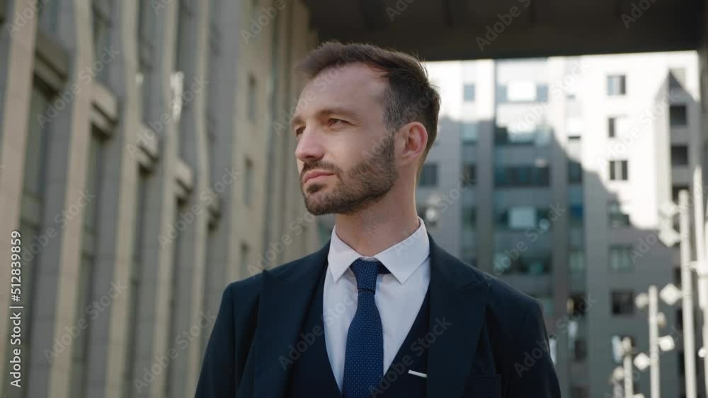 Portrait of confident ceo executive standing at downtown. Male businessman in 30s wearing classical suit posing outdoors on modern office building background Portrait of confident ceo executive standing at downtown. Male businessman in 30s wearing classical suit posing outdoors on modern office building background