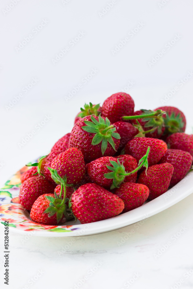 Ripe strawberries on a plate on a white background. Summer berries Ripe strawberries on a plate on a white background. Summer berries