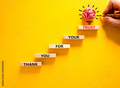 Thank you for trust symbol. Concept words Thank you for your trust on wooden blocks on a beautiful yellow table yellow background. Businessman hand. Business and thank you for trust concept.