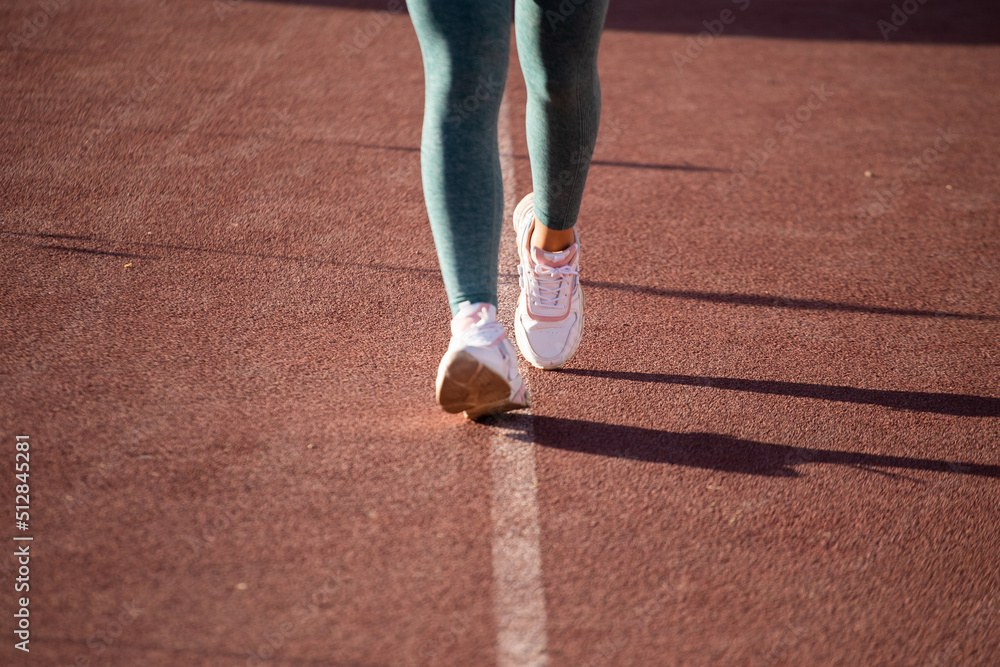 Detalle de pies de mujer corriendo en una pista atlética. Concepto de deportes y gente. Detalle de pies de mujer corriendo en una pista atlética. Concepto de deportes y gente.