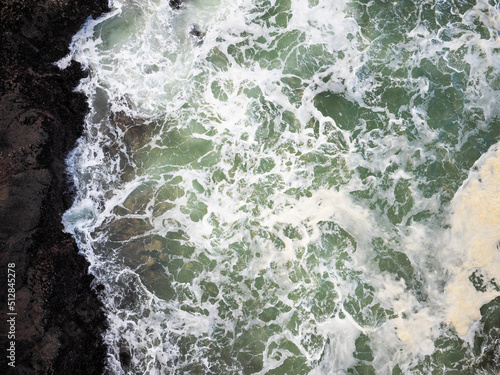 Shooting from a drone. Raging ocean, white foamy waves. Storm. The beauty and majesty of nature. There are no people in the photo. Abstraction. The danger of the elements, nature, ecology.