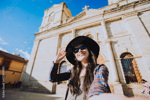 Selfie de mujer turista que disfruta sus vacaciones en una ciudad de Latinoamérica. Concepto de Personas, viajes y estilos de vida. photo