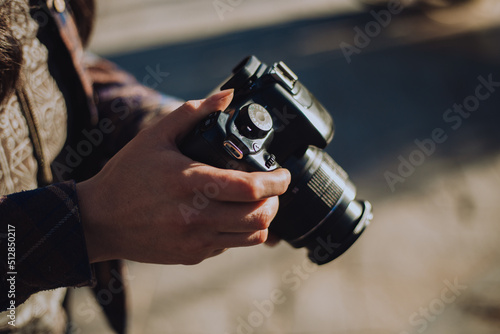 Obraz na płótnie manos de mujer sosteniendo una cámara fotográfica.