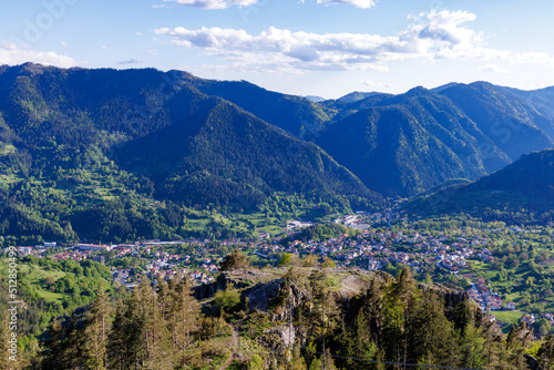 View from rock to town of Smolyan with meadows for cattle walking and houses between mountain range of Rhodope Mountains