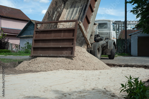 Dump trucks carrying good filling a field, giving rise to a fine soil. Preparation and construction.