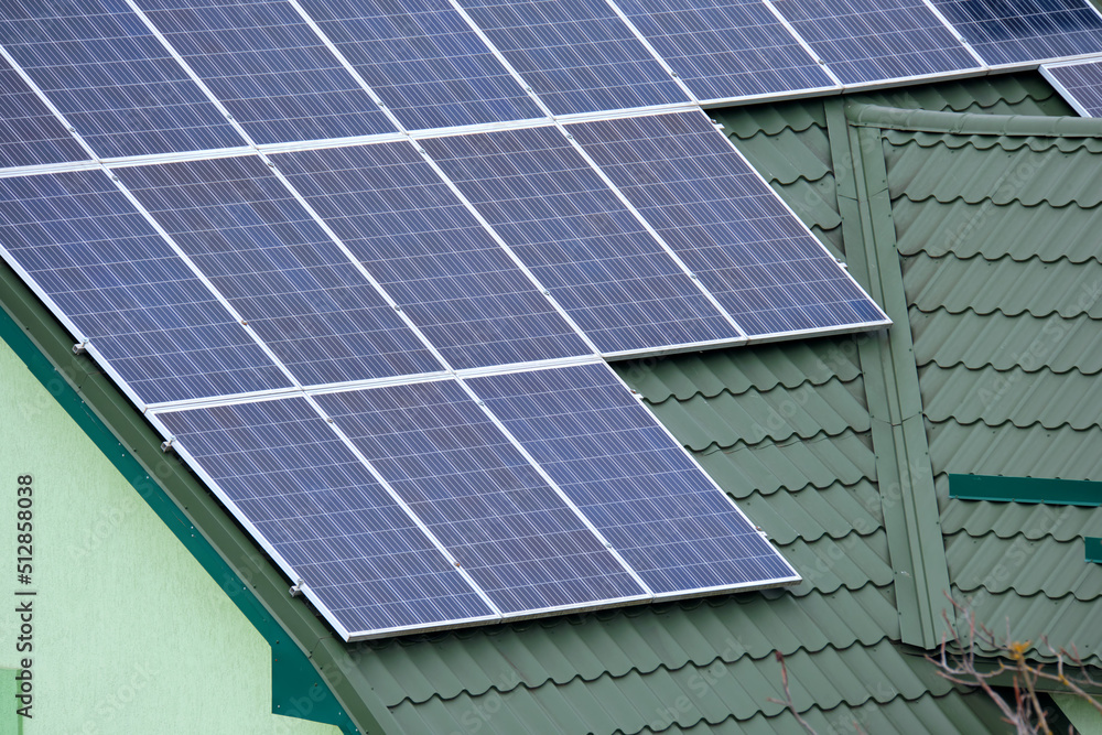 Fototapeta premium Residential house with rooftop covered with solar photovoltaic panels for producing of clean ecological electrical energy in suburban rural area. Concept of autonomous home
