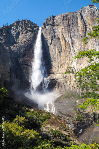 Vertical shot of Upper Yosemite Fall on a beautiful sunny summer day, Epic waterfall under blue sky in Yosemite National Park, California, USA. Natural wonders of the world.