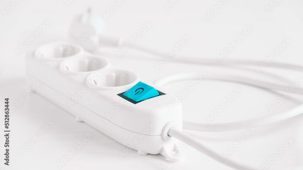 Modern white electric extension cord with a button on a white background Modern white electric extension cord with a button on a white background