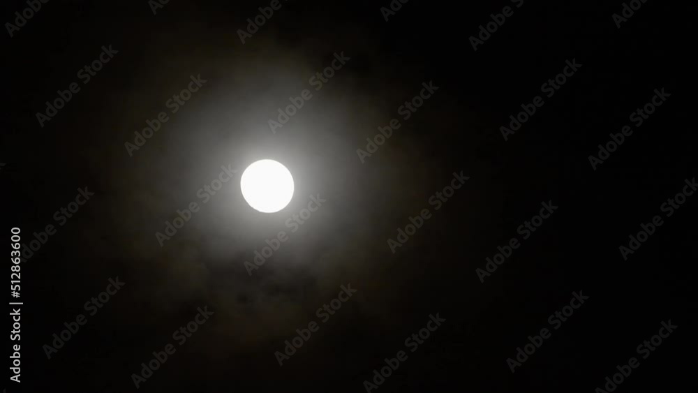 Thin clouds passing in front of moon and moving off to bottom left Thin clouds passing in front of moon and moving off to bottom left