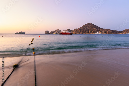 Fototapeta Naklejka Na Ścianę i Meble -  A fishing boat and yacht in front of Lands End and the Arch just before sunrise