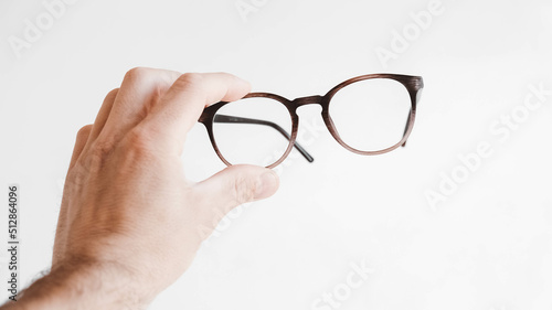 Round optical glasses in hand on a white background