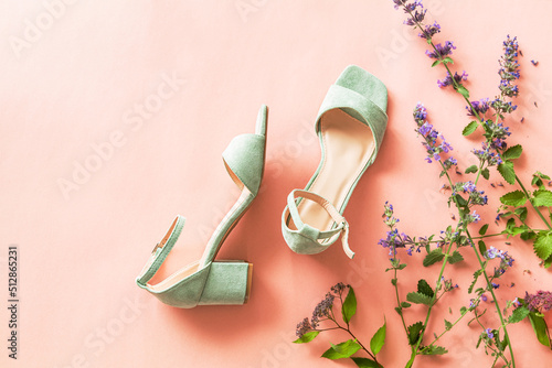 Fashion - summer footwear for woman. Pastel mint green sandals shoes and meadow flowers on pink