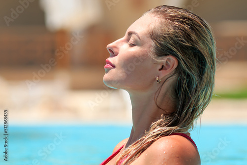 Young beautiful blond slim figure girl in pink bikini swim suit and sun glasses with sex sun tan relaxing chill in swimming pool with crystal blue water, summer vacation recreation positive vibes