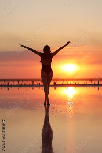 young slim beautiful woman on sunset beach  playful  dancing  running  bohemian outfit  indie style  summer vacation  sunny  having fun  positive mood  romantic  splashing water  silhouette  happy.