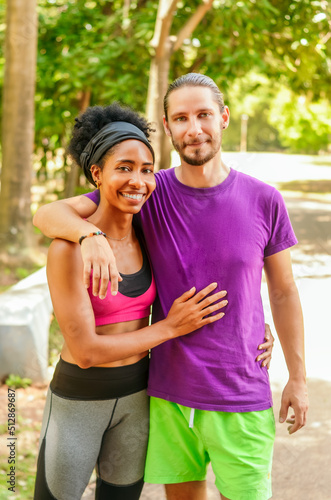 multiethnic couple hugging and happy in the park, afro girl with her partner