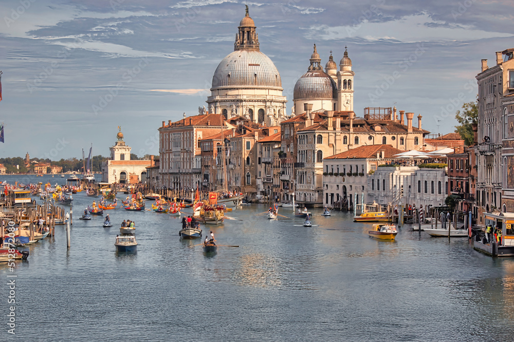 Venice, Italy: Boats sailing in the Grand canal and Basilica Santa Maria della salute against dramatic clouds
