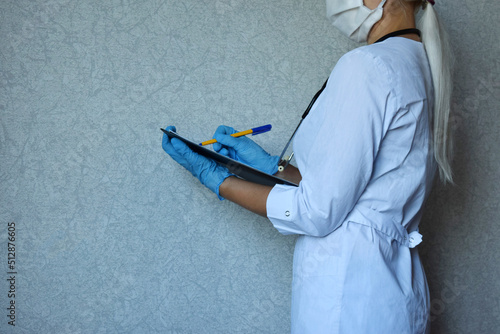 Wallpaper Mural Medicine, healthcare concept - close-up of a young girl doctor in blue gloves filling out a medical report at the hospital. Torontodigital.ca