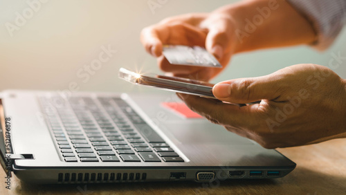 Businessman using laptop computer with a credit card making an online order. Business, online shopping, e-commerce, internet banking, spending money, online payment, working from home concept.