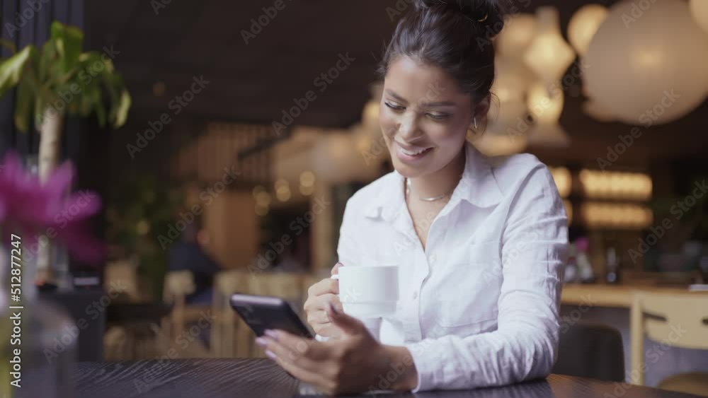 Beautiful Latin girl using her mobile phone in cafe. Cinematic 4K Beautiful Latin girl using her mobile phone in cafe. Cinematic 4K