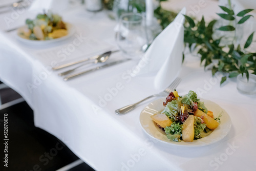 Banquet table with dish. Dish with croissant and pate. Decorating the table with flowers and greenery.