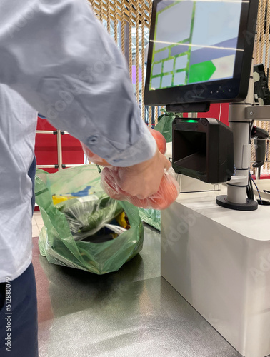 Customer pays his purchase at the supermarket,self checkout systems in retail stores,Barcode scanner,Self checkout machine