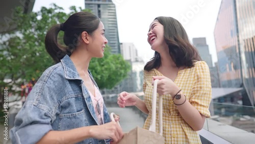 Asian two female close friends having a goodtime seeing each other since long time no see, outdoor shot inside city downtown, shopping day, spending hours at department store, talking and laughing photo