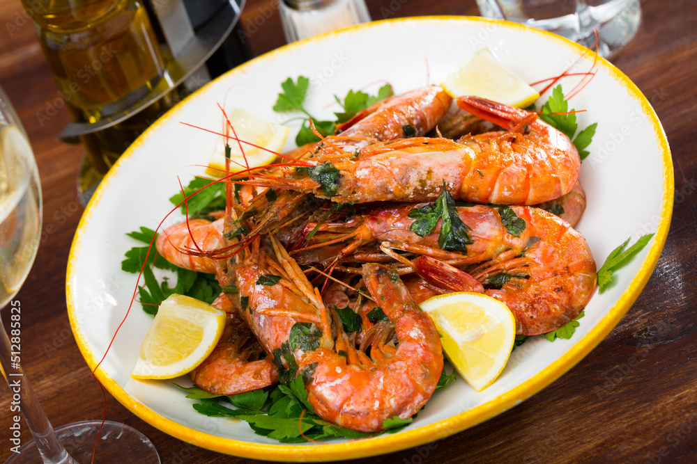 Seafood appetizer. Roasted prawns served with parsley and lemon slices..