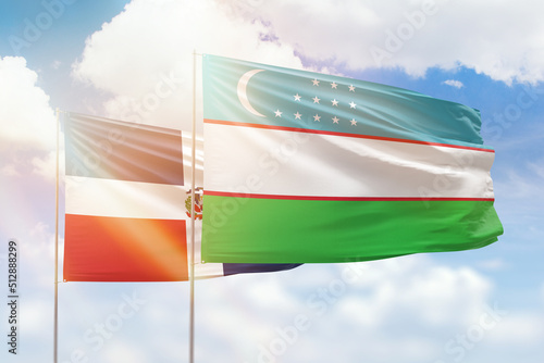 Sunny blue sky and flags of uzbekistan and dominican republic