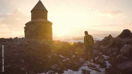 Man is walking in front of the Saint Gregory church on sunset at Ani ancient city Kars Turkey photo