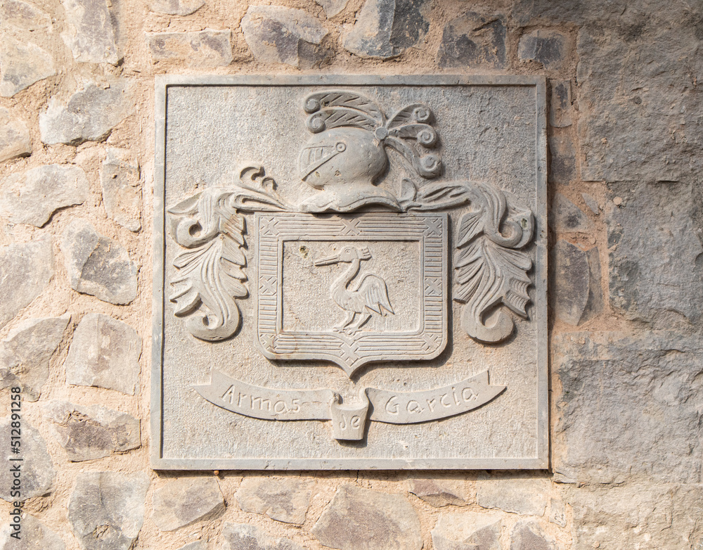 medieval coat of arms shield sculpture in a stone wall with the legend or inscription 