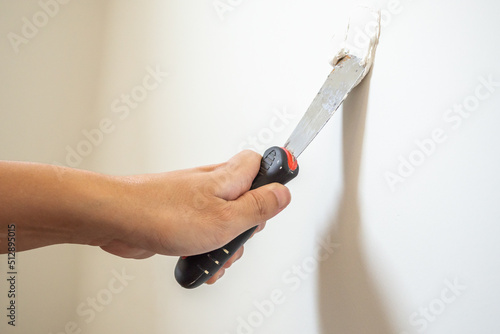 Wallpaper Mural Man repairing crack white wall with spatula Torontodigital.ca