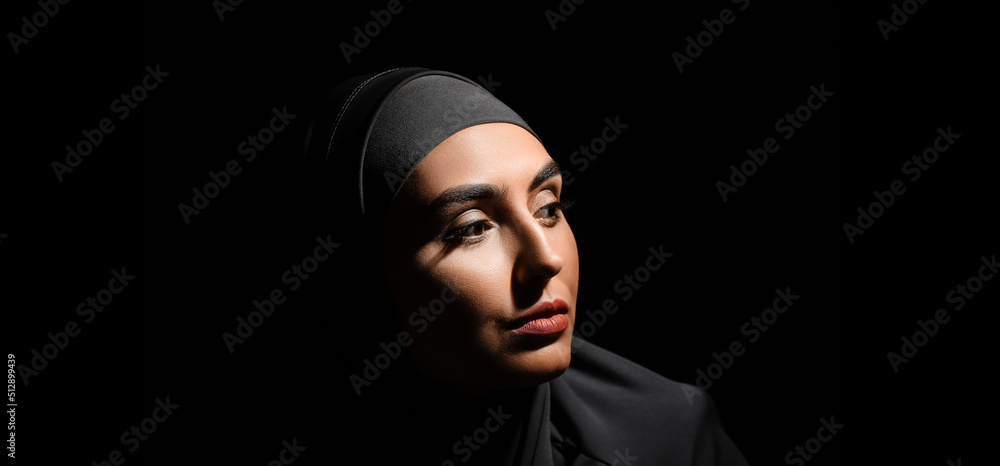 Portrait of beautiful Muslim woman on dark background