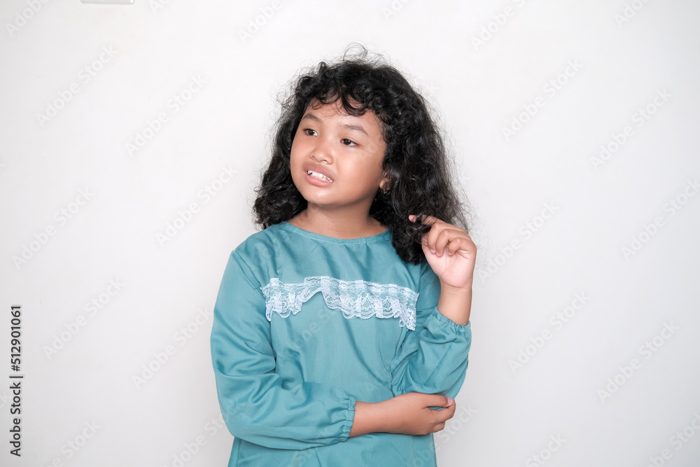 Cute smiling Asian little girl playing with her curly hair, isolated on white studio background. Cute smiling Asian little girl playing with her curly hair, isolated on white studio background.