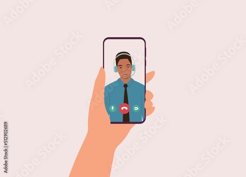 Person’s Hand Holding Mobile Phone With Black Male Customer Service Representative Talking Through Video Call. Close-Up. Character, Cartoon.