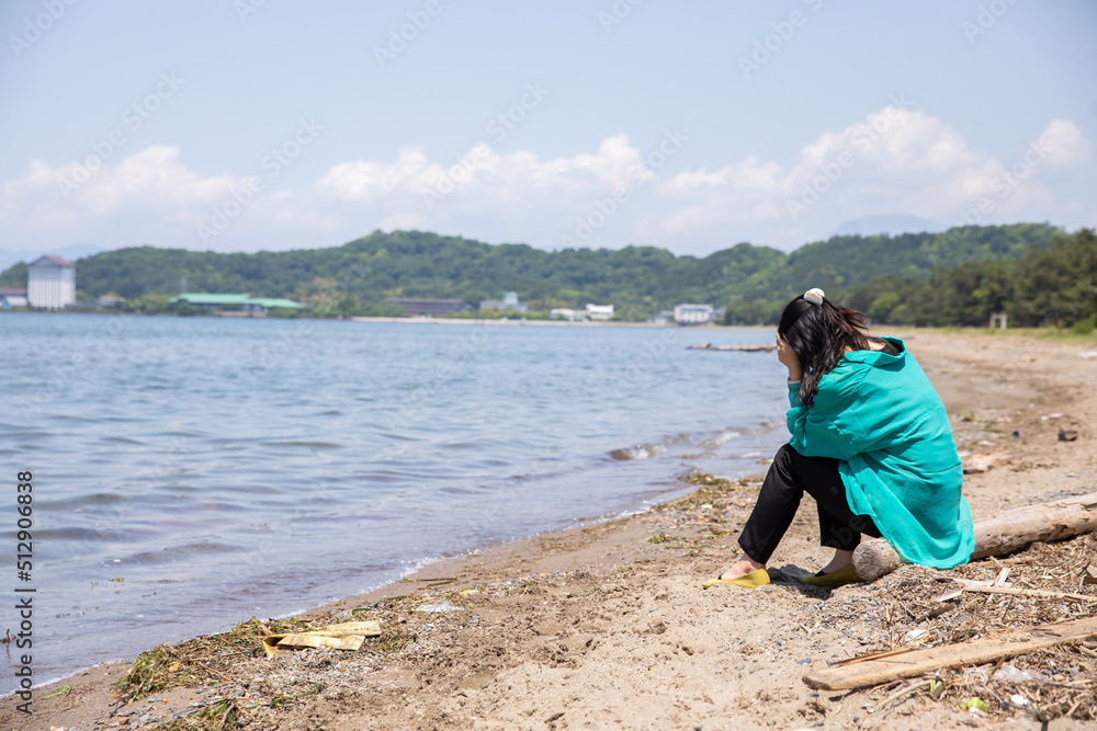 浜辺で頭を抱える女性　beach