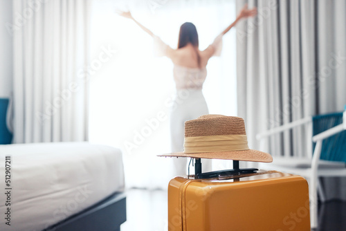 Canvastavla Close-up luggage with hat and blurred happy tourist woman background in hotel after check-in