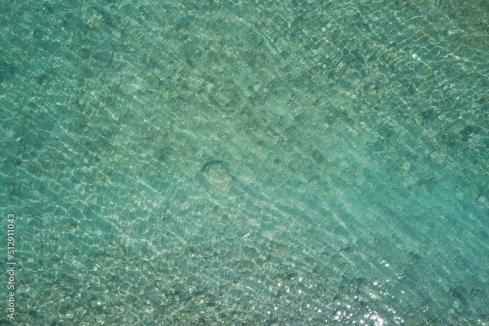 clear water top. Turquoise blurred water top view. Stones at the bottom of the water aerial view. clear water top. Turquoise blurred water top view. Stones at the bottom of the water aerial view.
