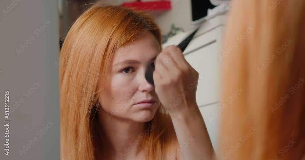 Redhead woman applies makeup and gets ready for work Redhead woman applies makeup and gets ready for work