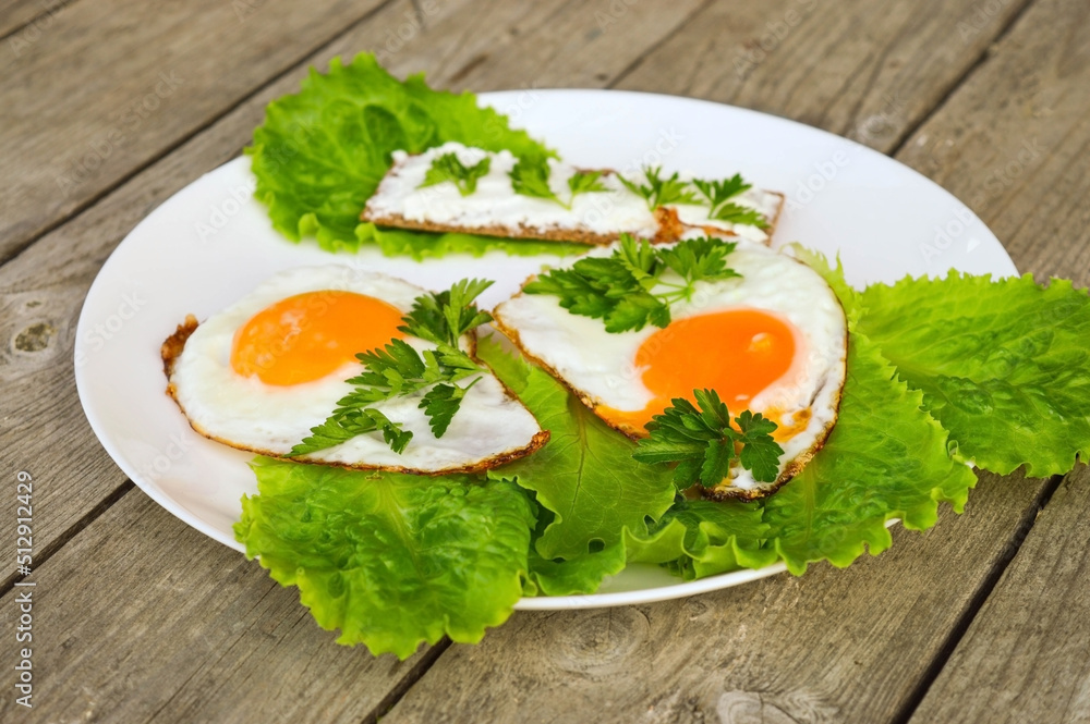 Healthy breakfast - fried eggs, bread with cheese and fresh parsley on a white plate Healthy breakfast - fried eggs, bread with cheese and fresh parsley on a white plate