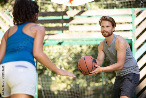 handsome male playing basketball with girlfriend