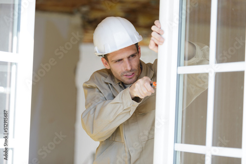 worker installing plastic window handle