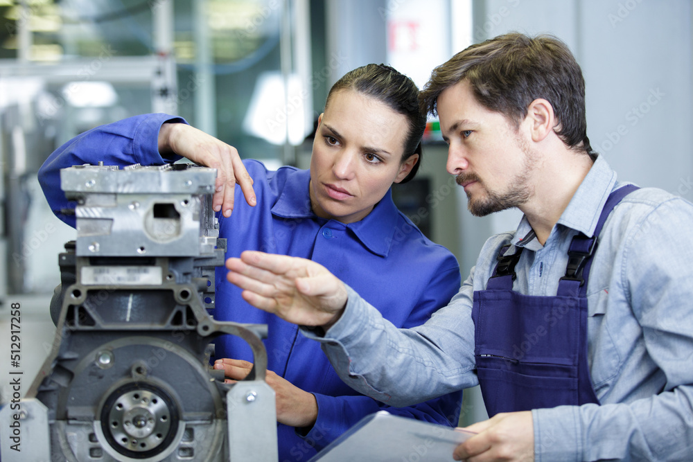 foreman explaining working of a motor to female trainee foreman explaining working of a motor to female trainee